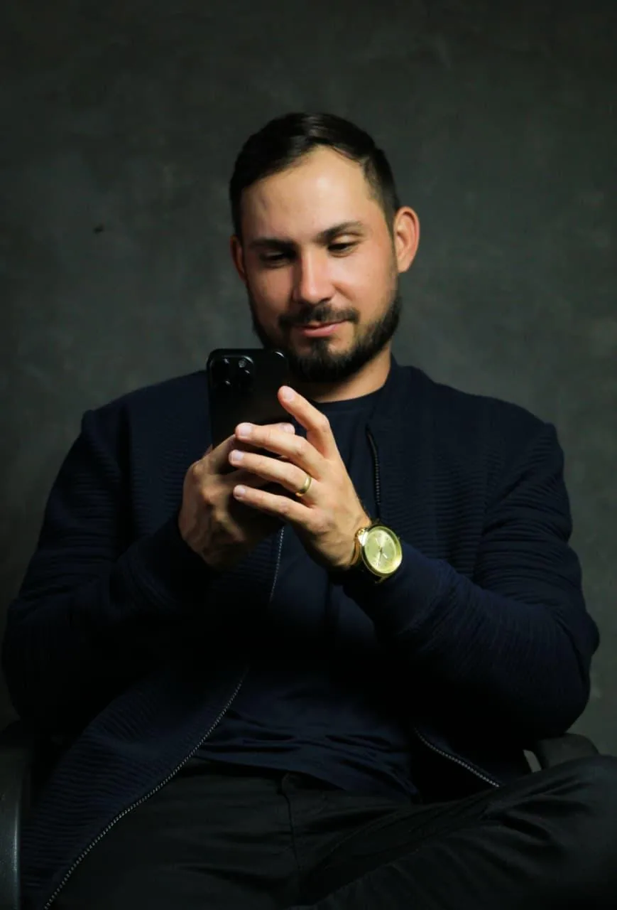 Luan Silva sentado, filmando com o celular